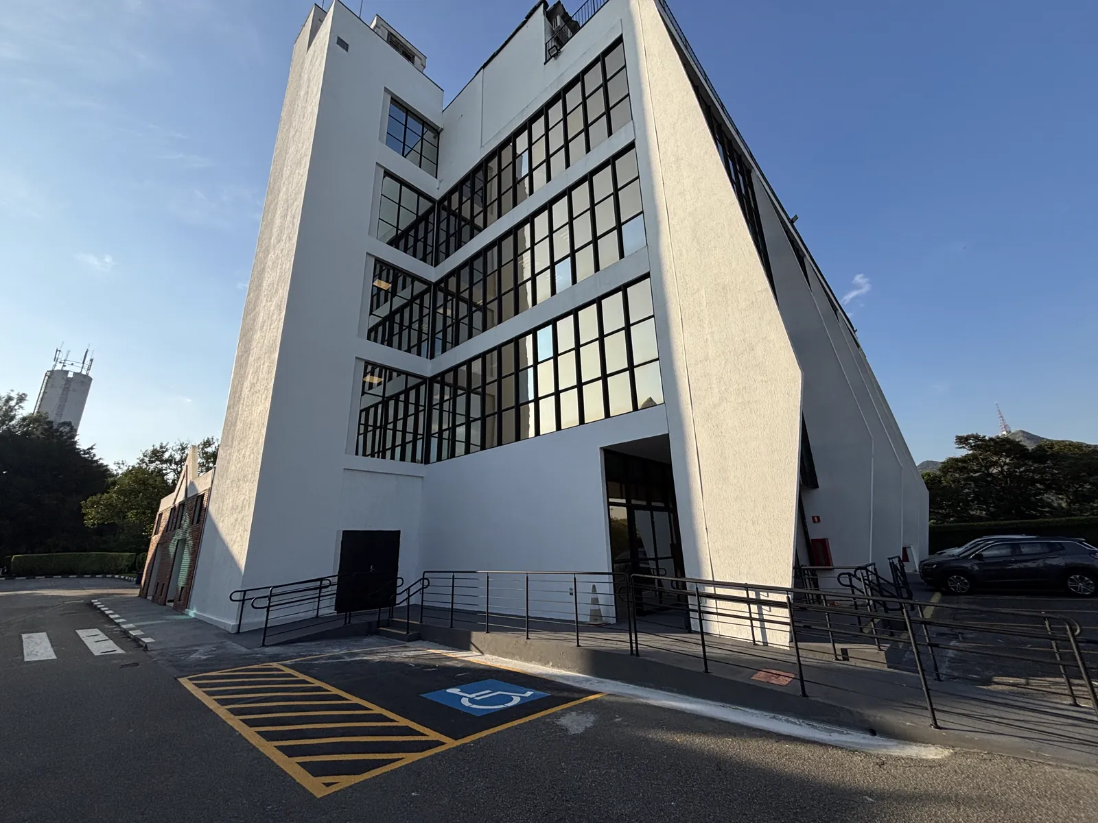 Depois: esquina com rampa, guarda-corpo e vaga acessível